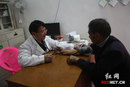 李石清正在给71岁的村民凡冬林量血压。